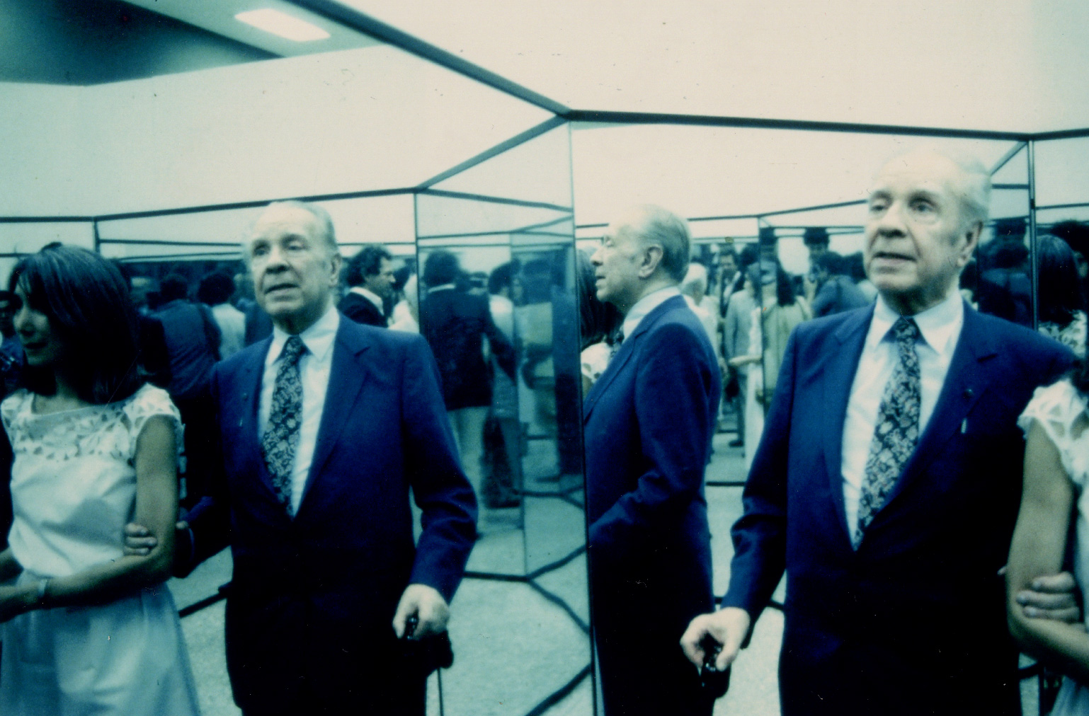 Borges y Kodama caminando por un laberinto de espejos que formaba parte de la exposiciÃ³n de Kern sobre laberintos. Al fondo tambiÃ©n se puede ver a Franco Maria Ricci. Milan, 1981. 