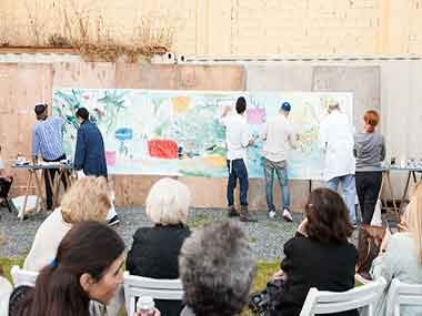 Los pintores realizando el Homenaje a Majo Okner