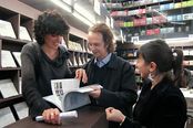 Benedetta Carpi di Resmini, Willy Goldschmidt y Laura Escobar observando el catálogo de la muestra